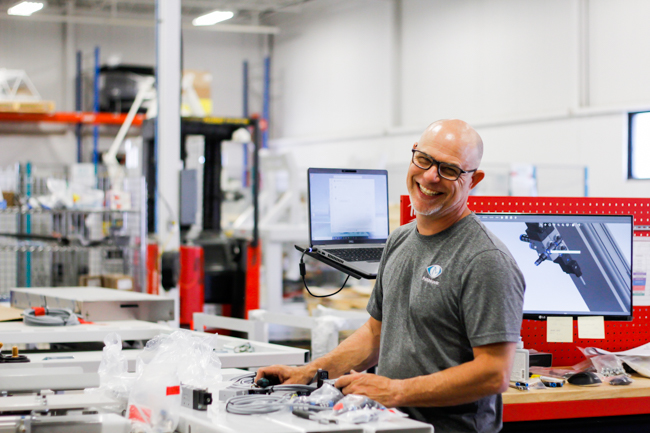 Un employé de NūMove souriant dans l'entrepôt