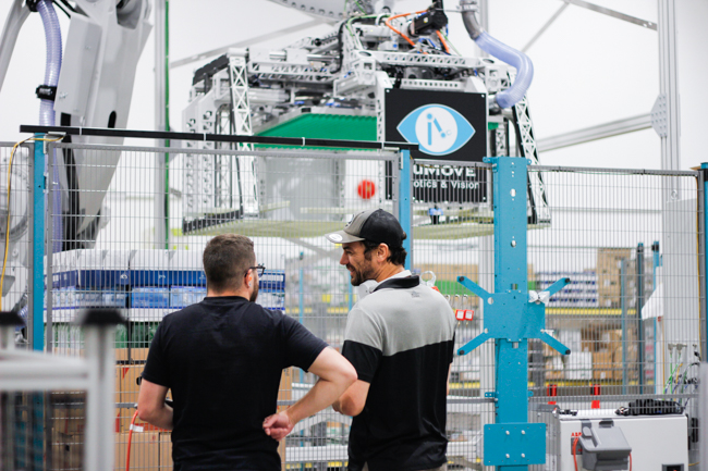numove programmer and mechanical designer in front of a robotic depalletizing cell